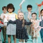 Dzieci w przedszkolu bawią się balonami w kolorowych kostiumach