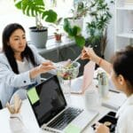 Trzy kobiety jedzą sałatkę podczas przerwy w pracy biurowej