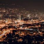 Nocna panorama Medellín z oświetlonymi wieżowcami i światłami miasta