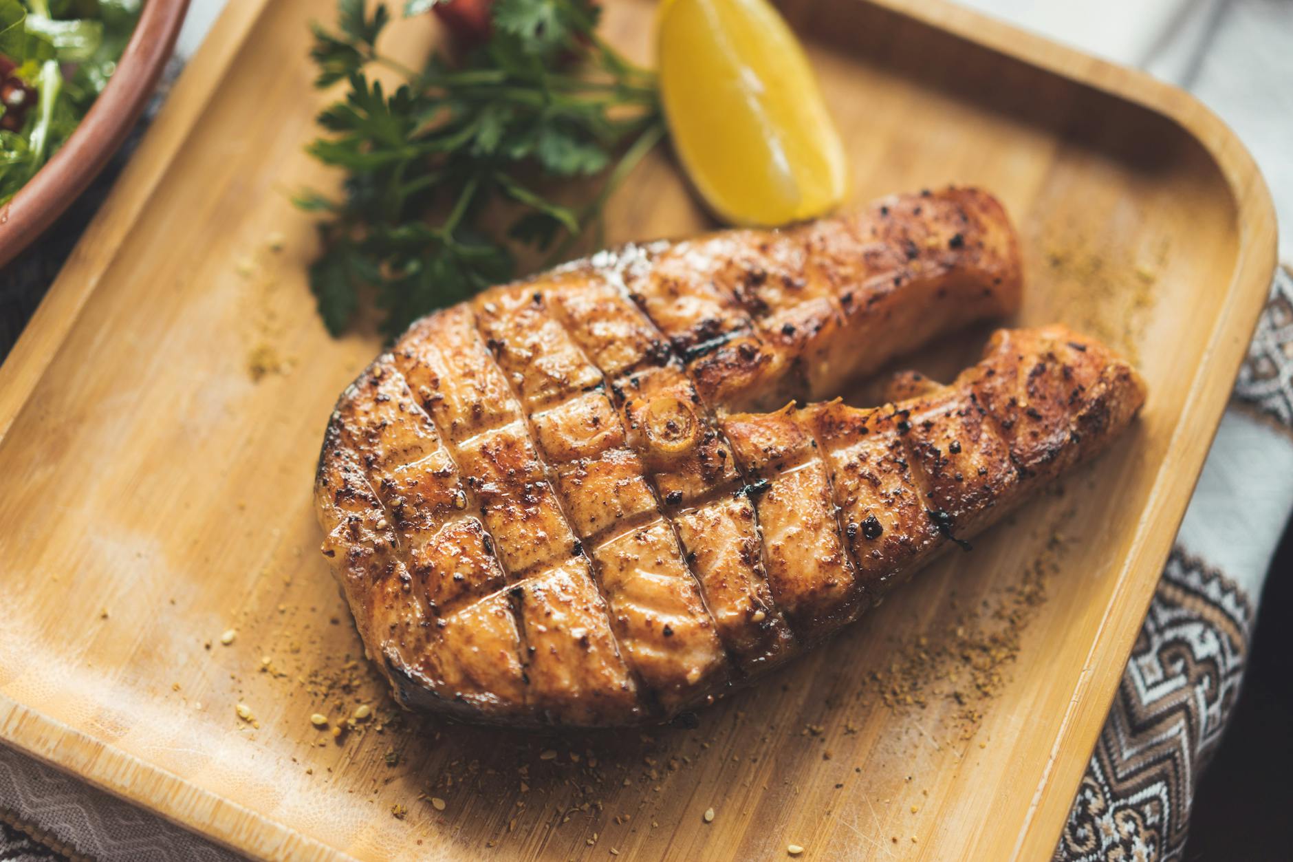 Grillowany filet z łososia z ziołami i cytryną na drewnianej desce