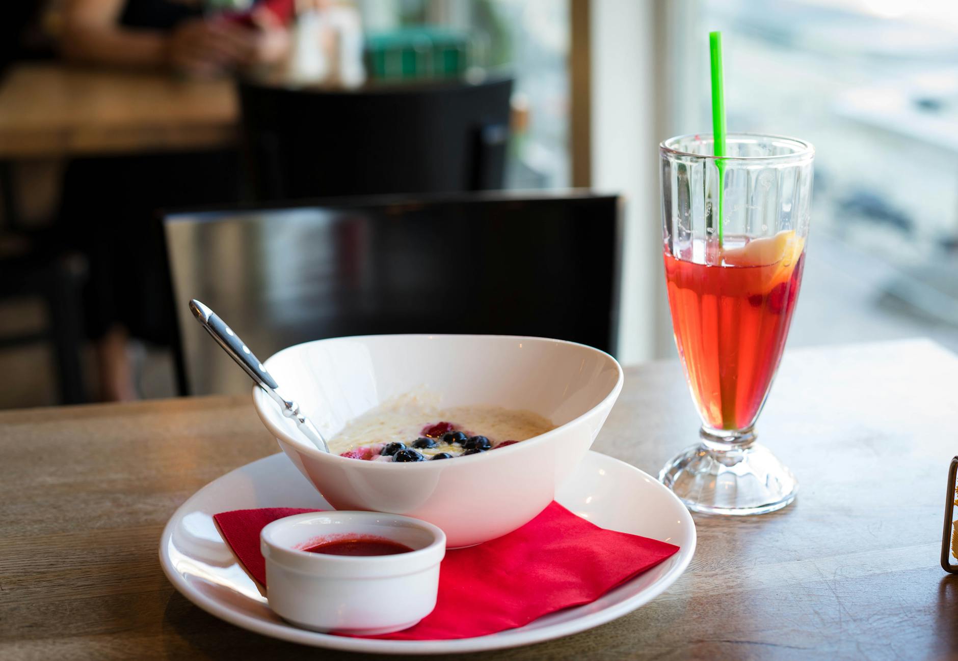 Miska kaszy jaglanej z sokiem owocowym na kawiarnianym stoliku