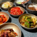 Koreańskie przystawki banchan w metalowych miseczkach na stole