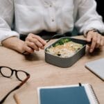 Pracownik je zdrowy lunch przy biurku w pracy