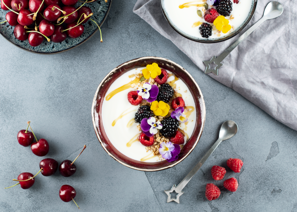 Miska jogurtu z jeżynami, malinami i czereśniami widziana z góry